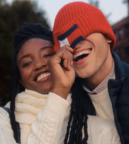 Two young adults wearing Tommy Hilfiger winter apparel