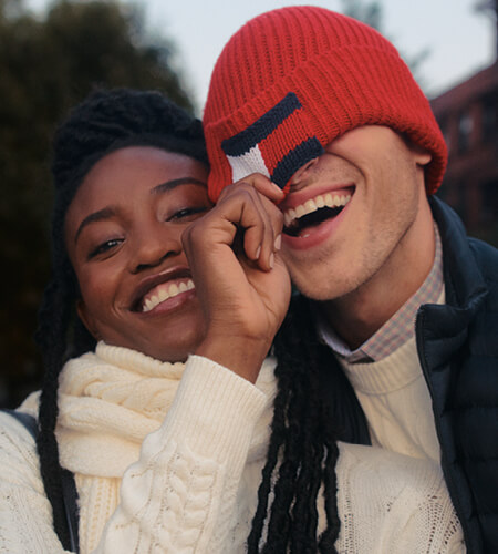 Two young adults wearing Tommy Hilfiger winter apparel