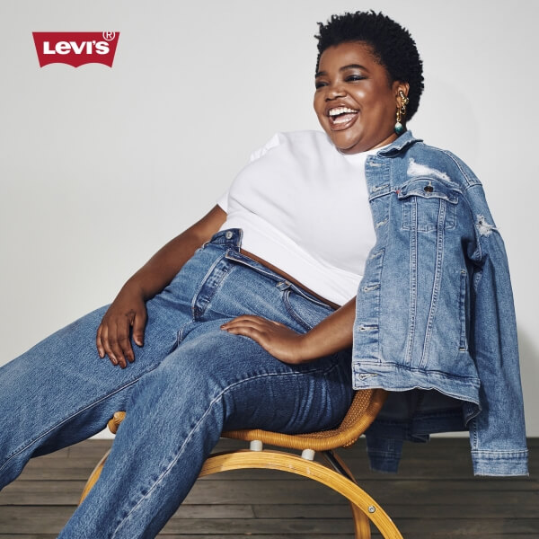 Model wearing Levi's jeans and white t-shirt with a denim jacket over the shoulder