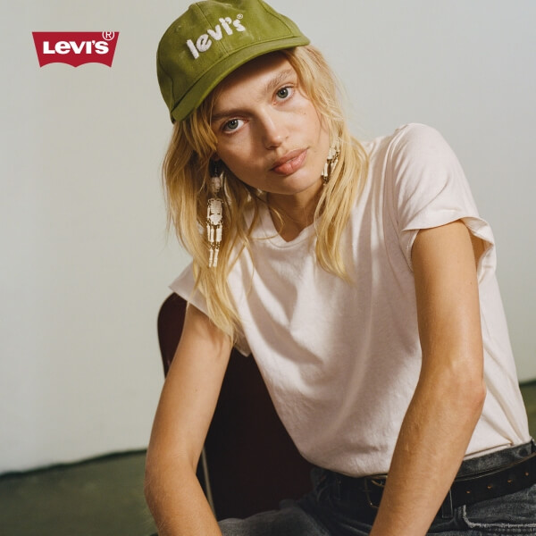 Model wearing a green Levi's baseball cap, white t-shirt, and jeans