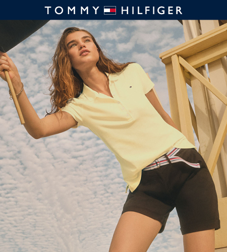 Model wearing Tommy Hilfiger yellow polo shirt and black shorts