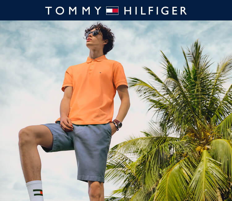 Model wearing Orange Tommy Hilfiger shirt and blue shorts