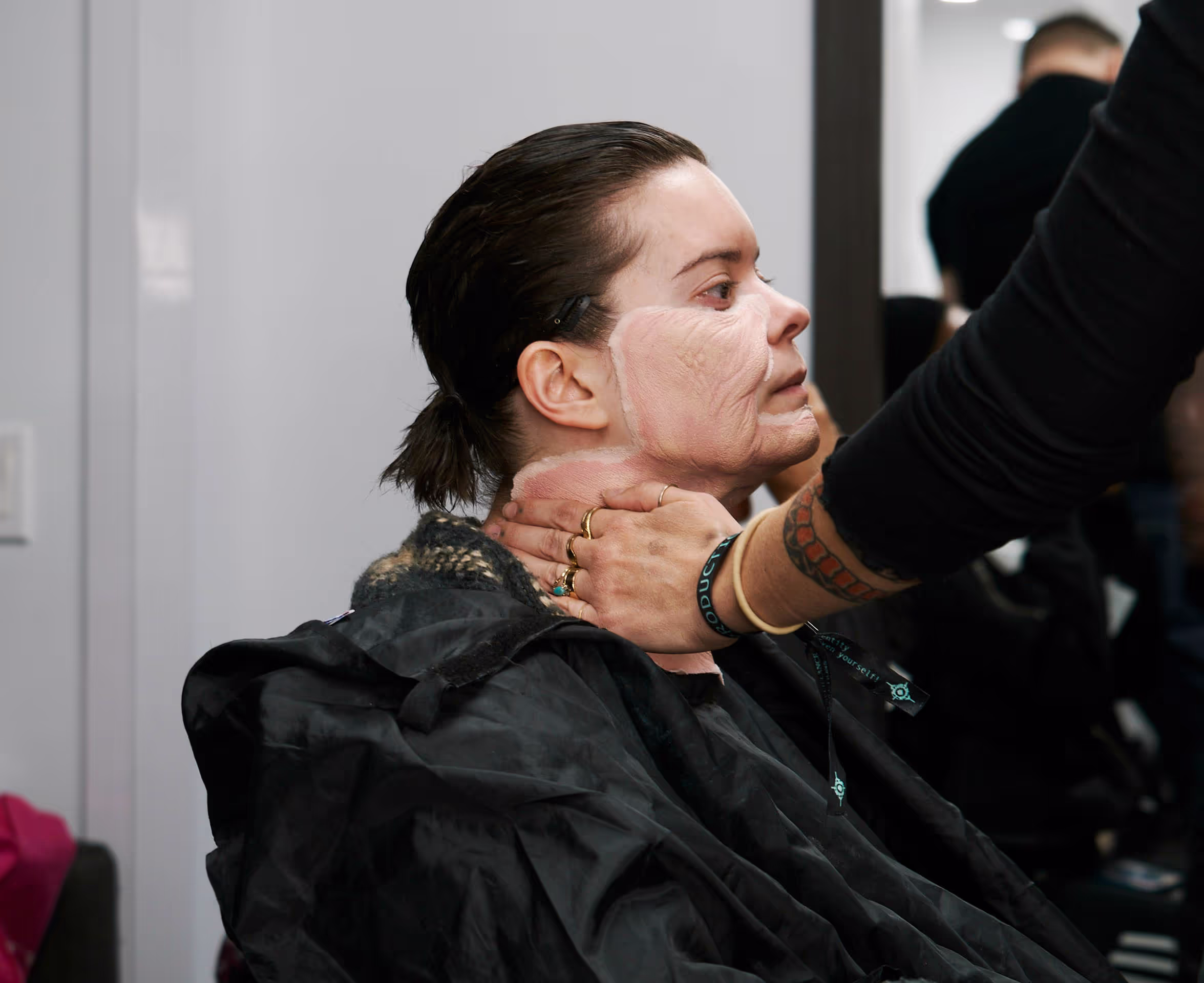 a person getting prosthetic makeup put on them 