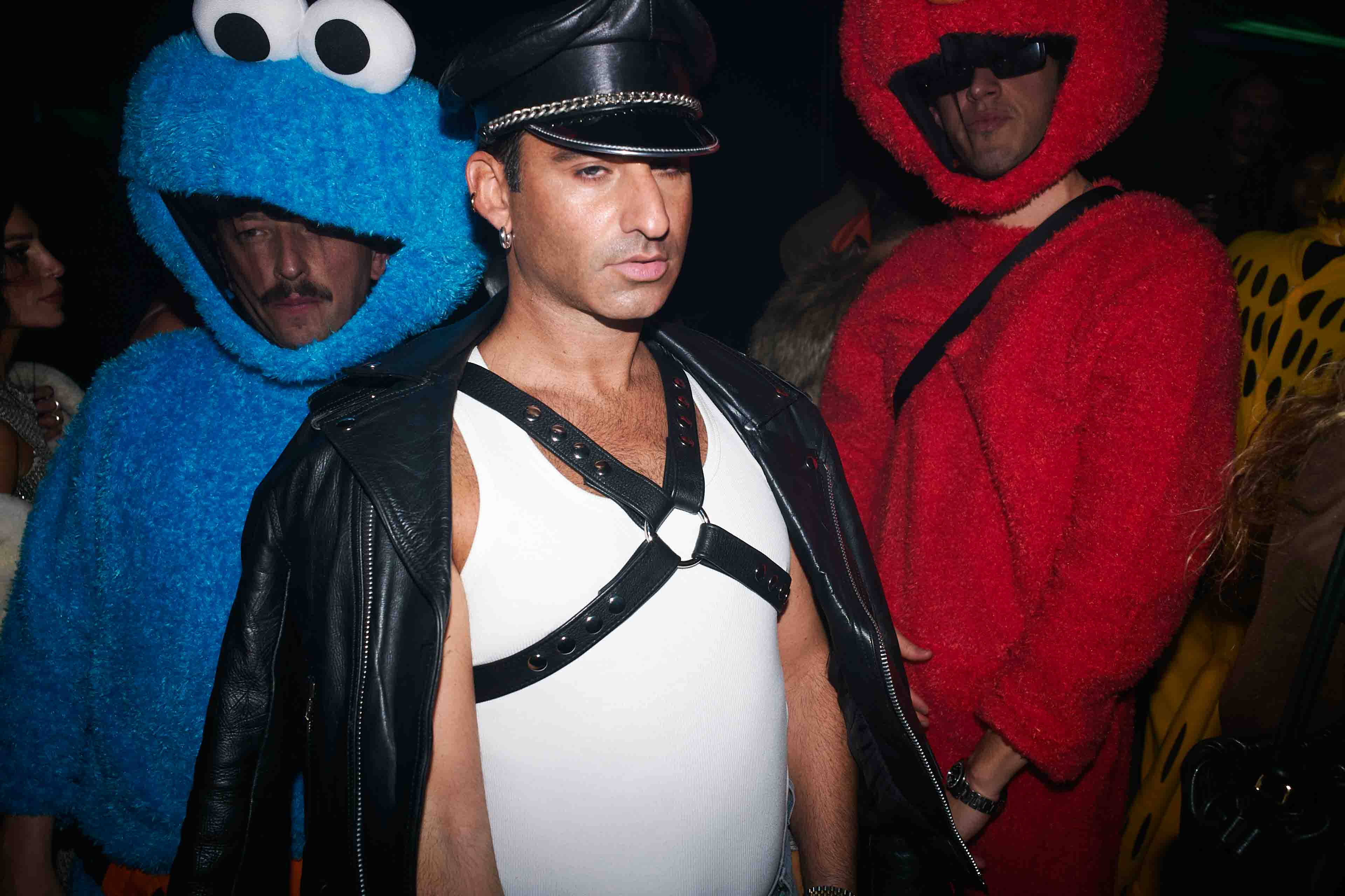 A man in a costume standing next to two sesame characters.