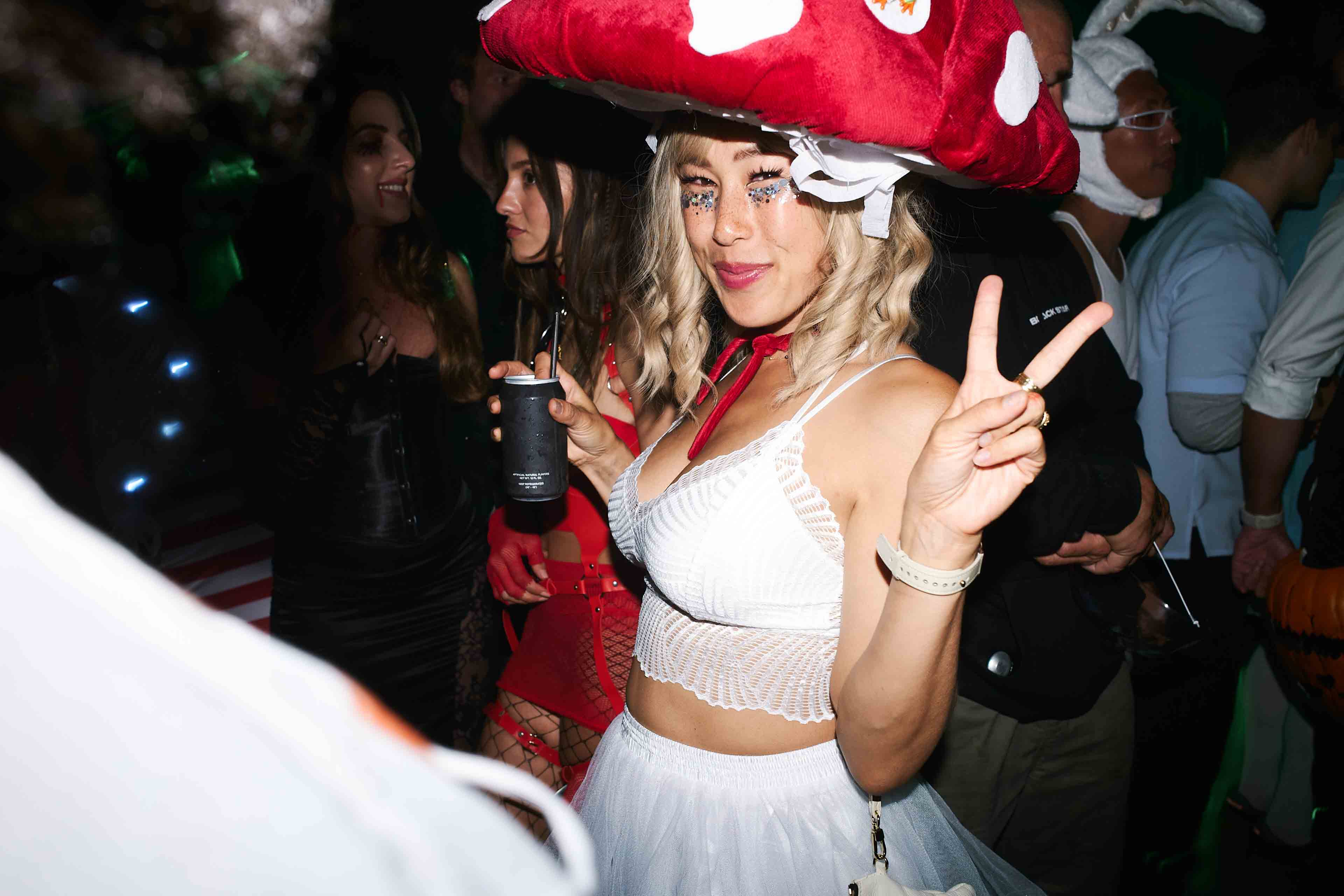 A woman in a white dress and a red mushroom hat.