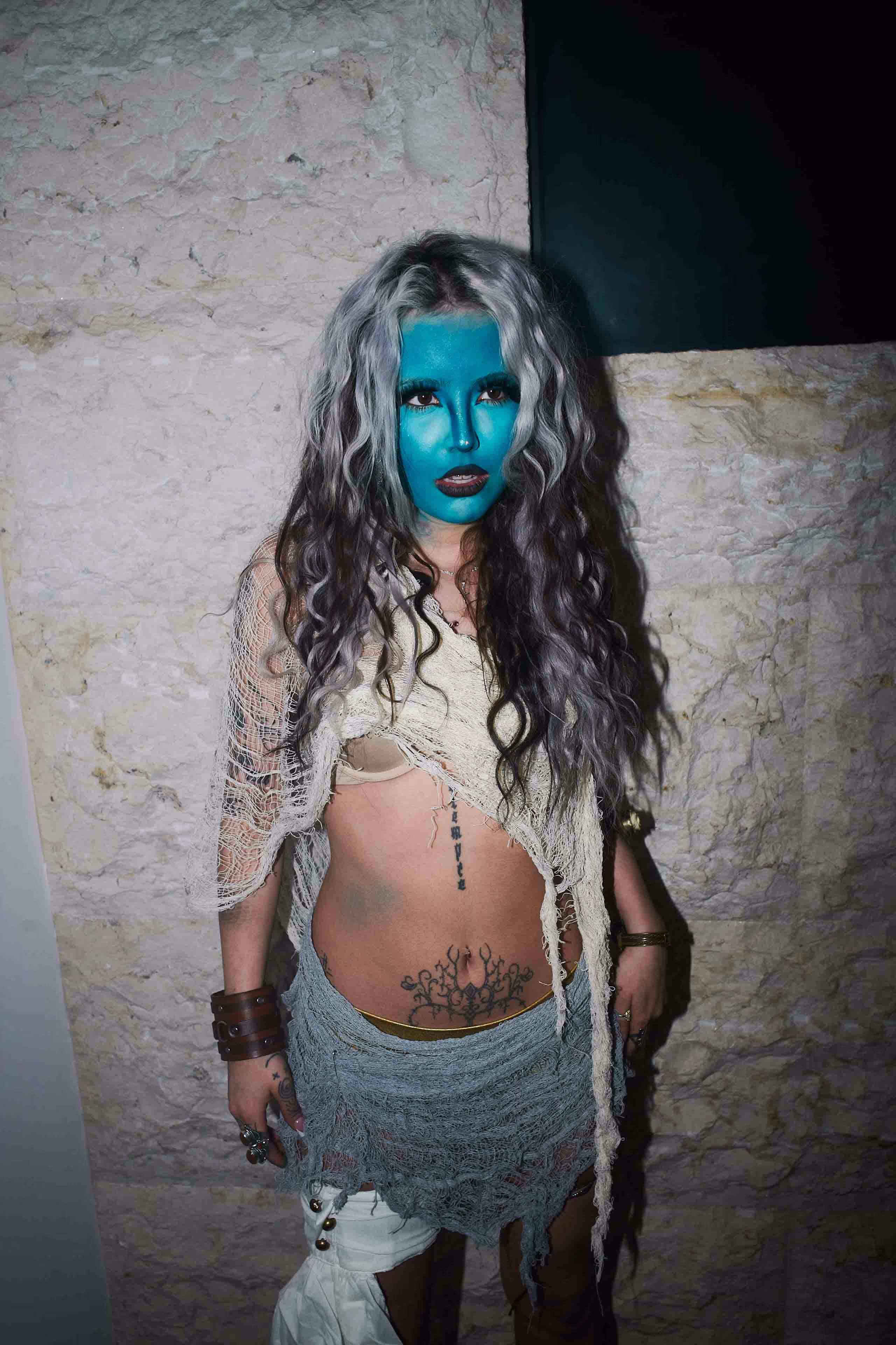 A woman with blue makeup and white hair.
