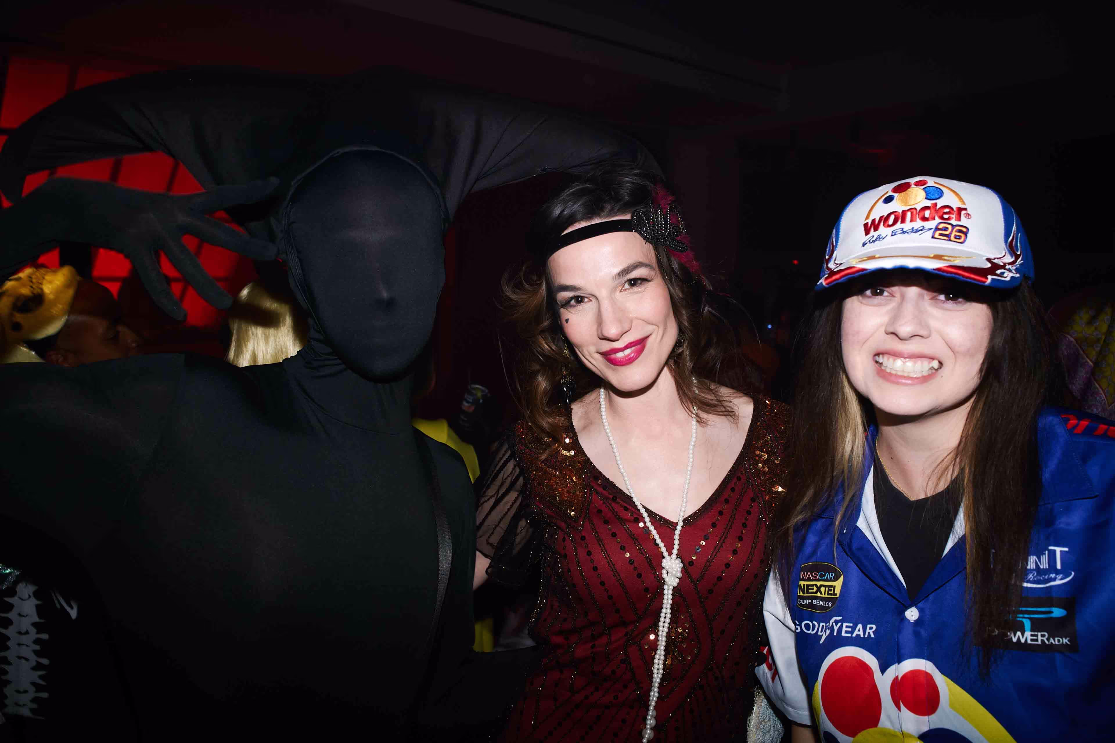 Two women standing next to each other at a party.