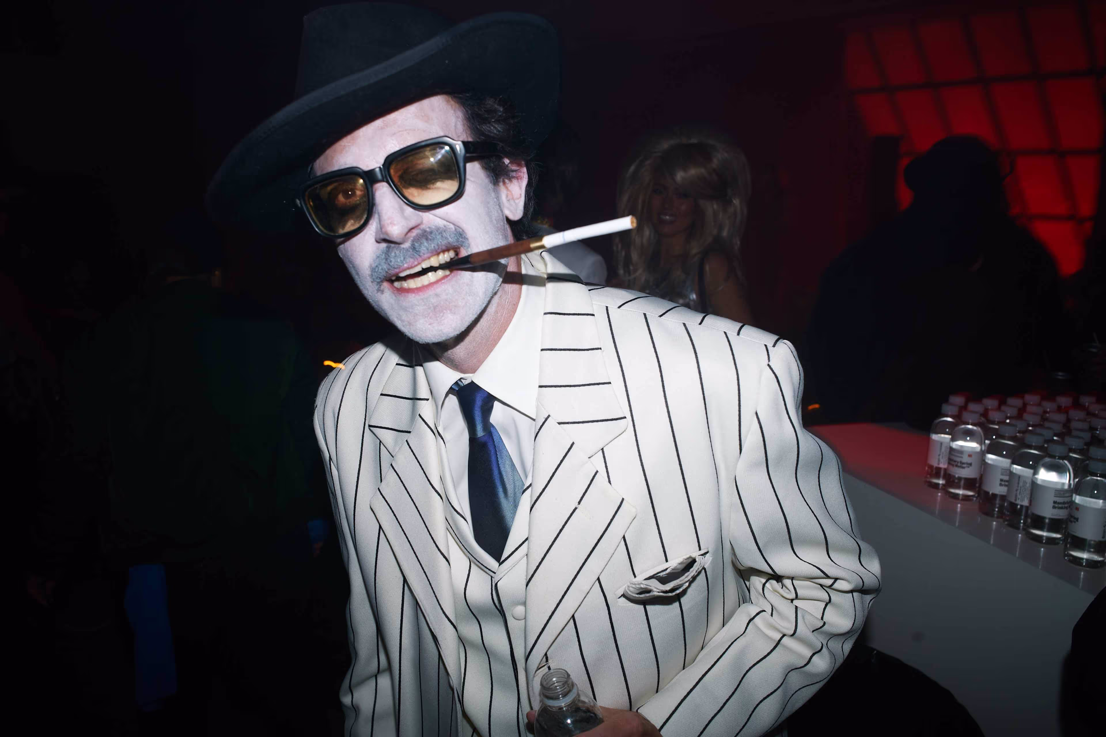A man in a pinstripe suit smoking a cigarette.