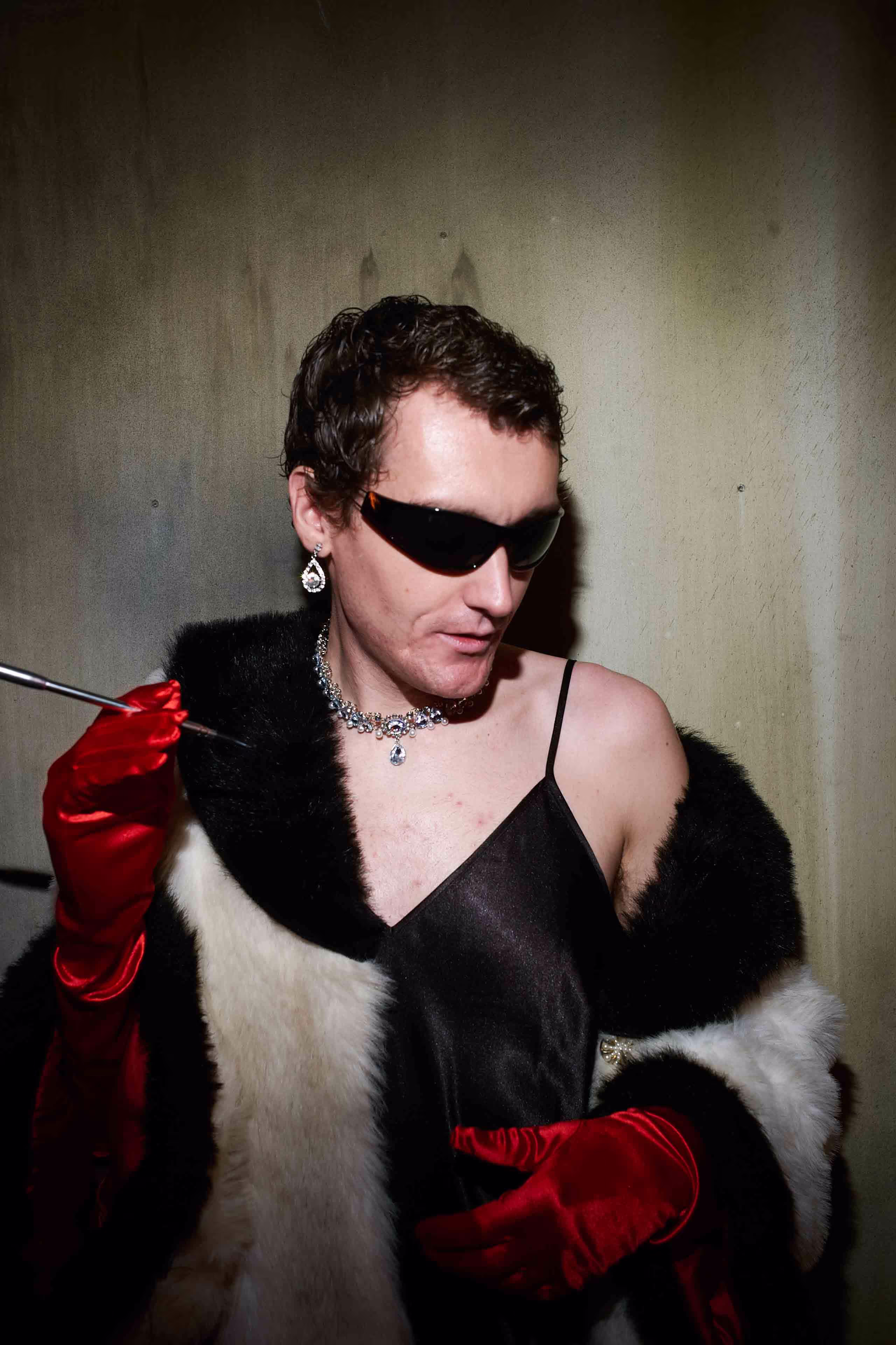 A woman in a black dress and red gloves.