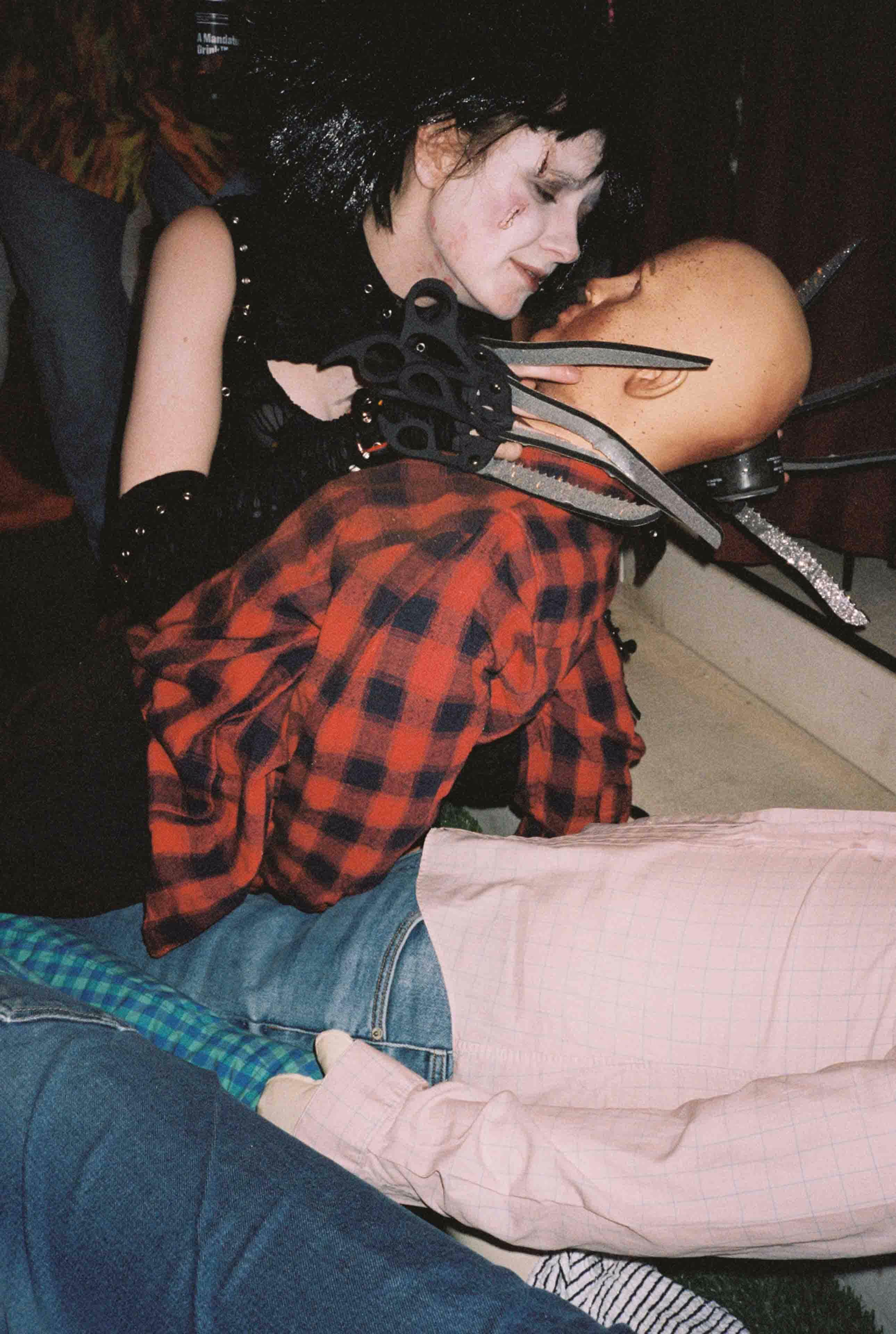 A woman sitting on the floor with scissors in her hands.