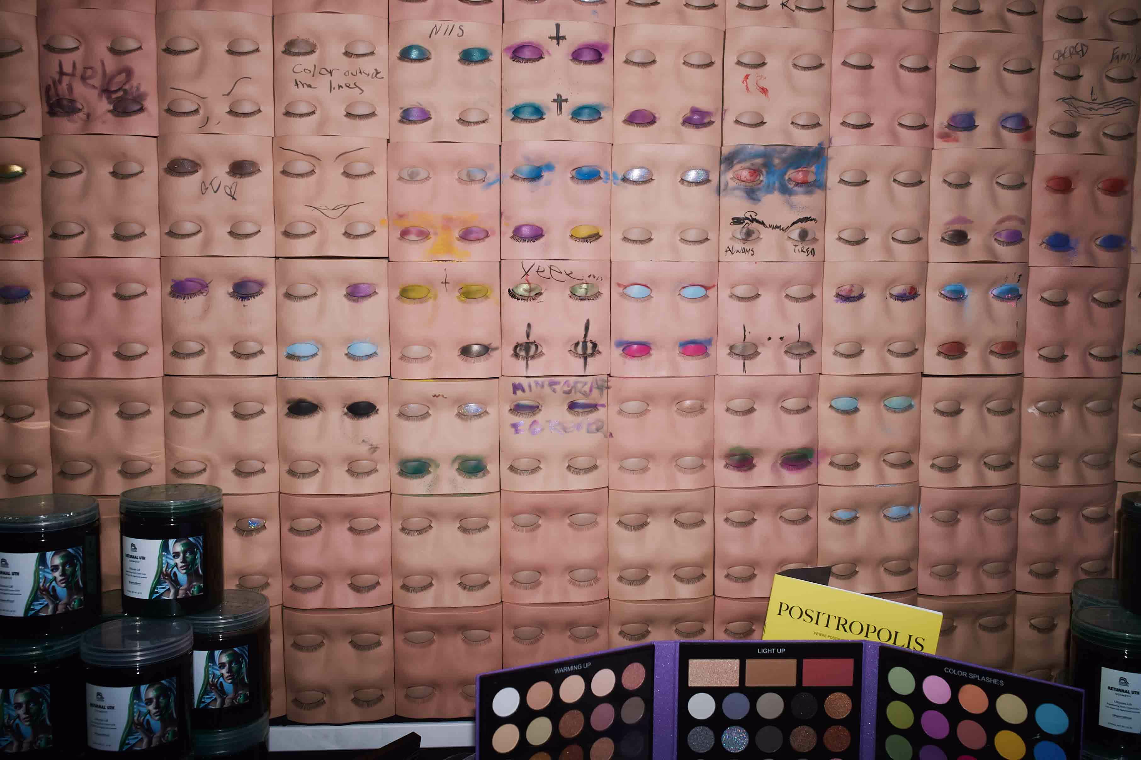 A wall covered in lots of different colored eyeshades.