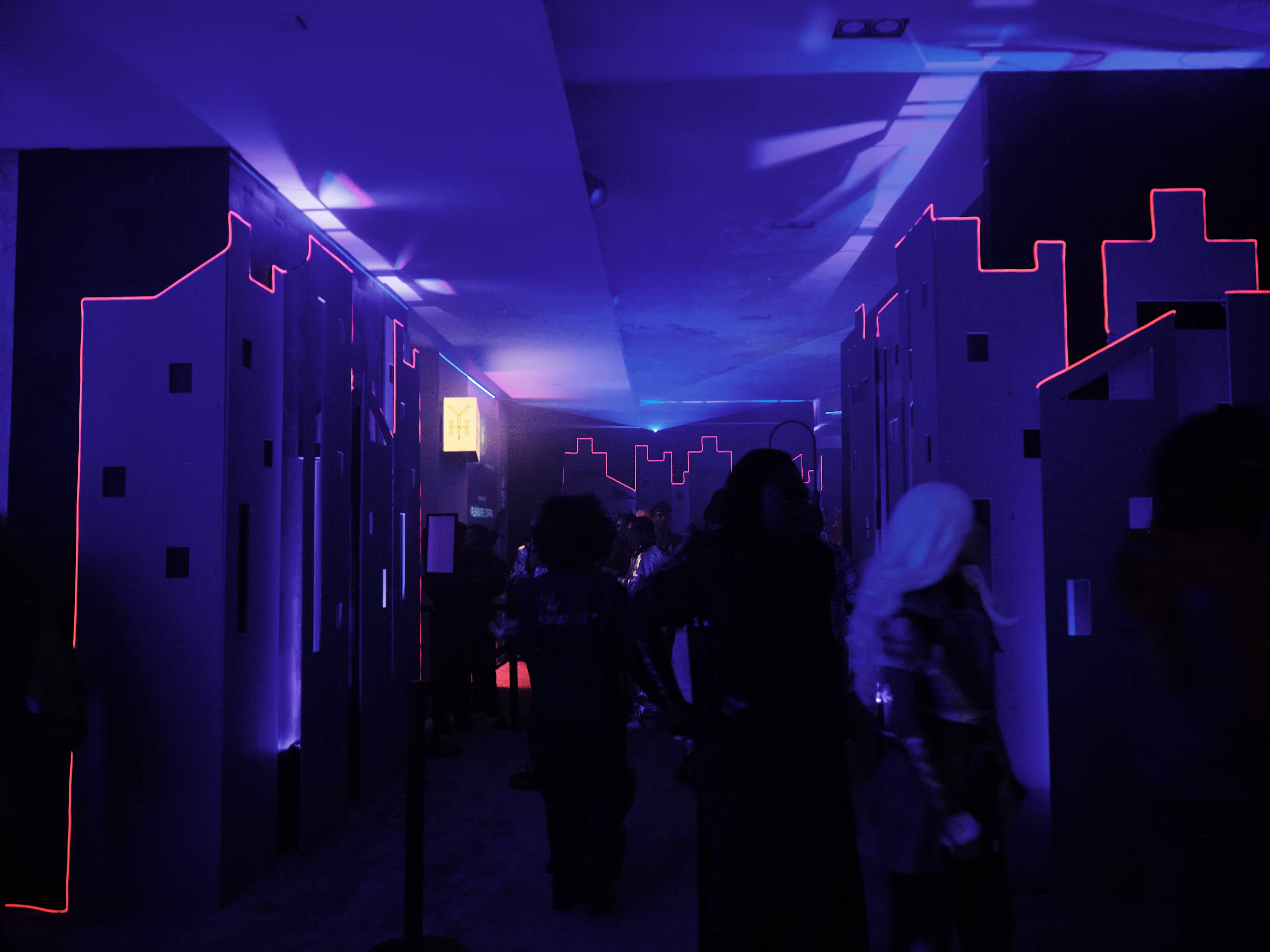 A group of people standing in a hallway next to lockers.