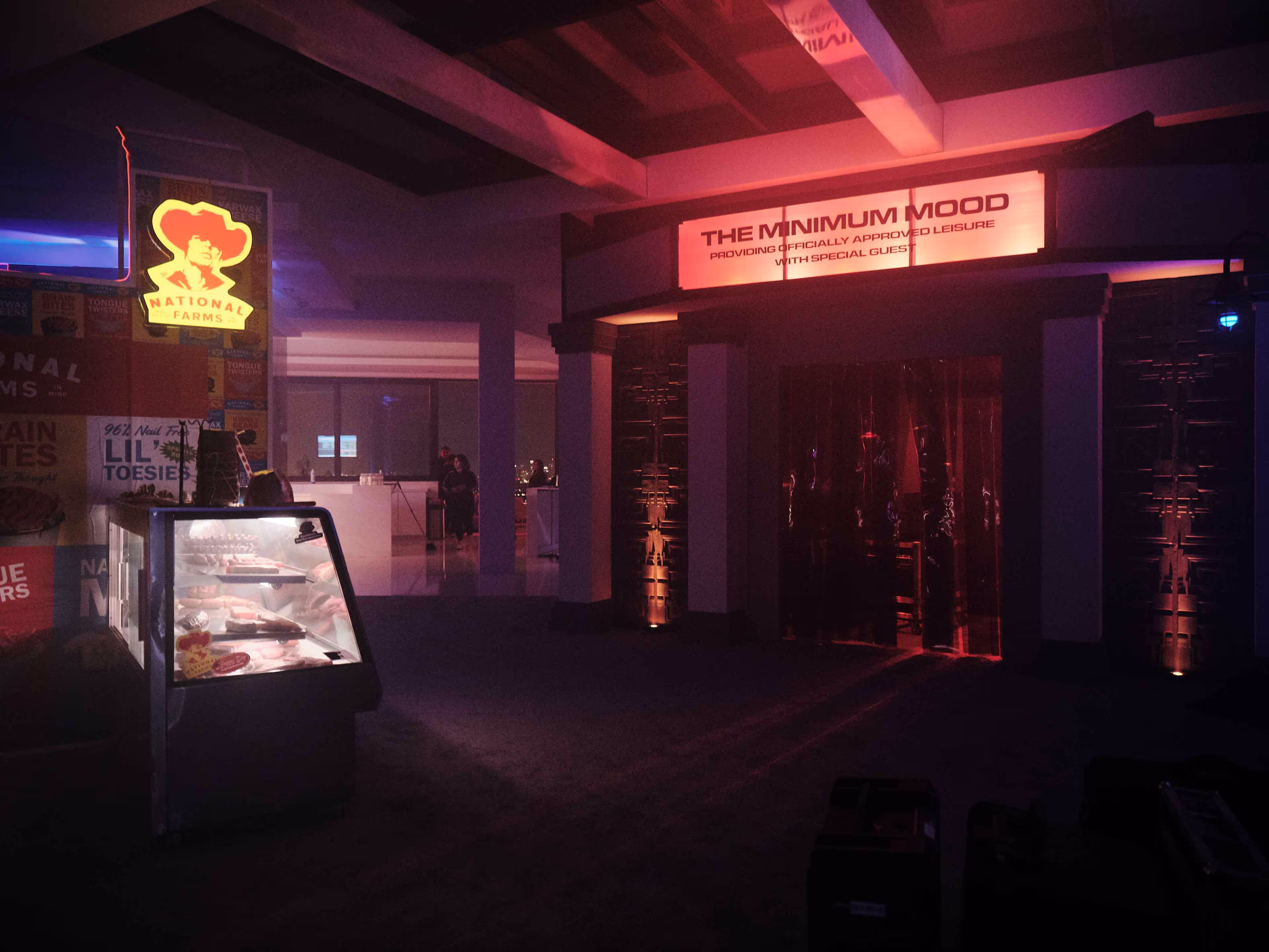A display case in a dark room with a neon sign above it.