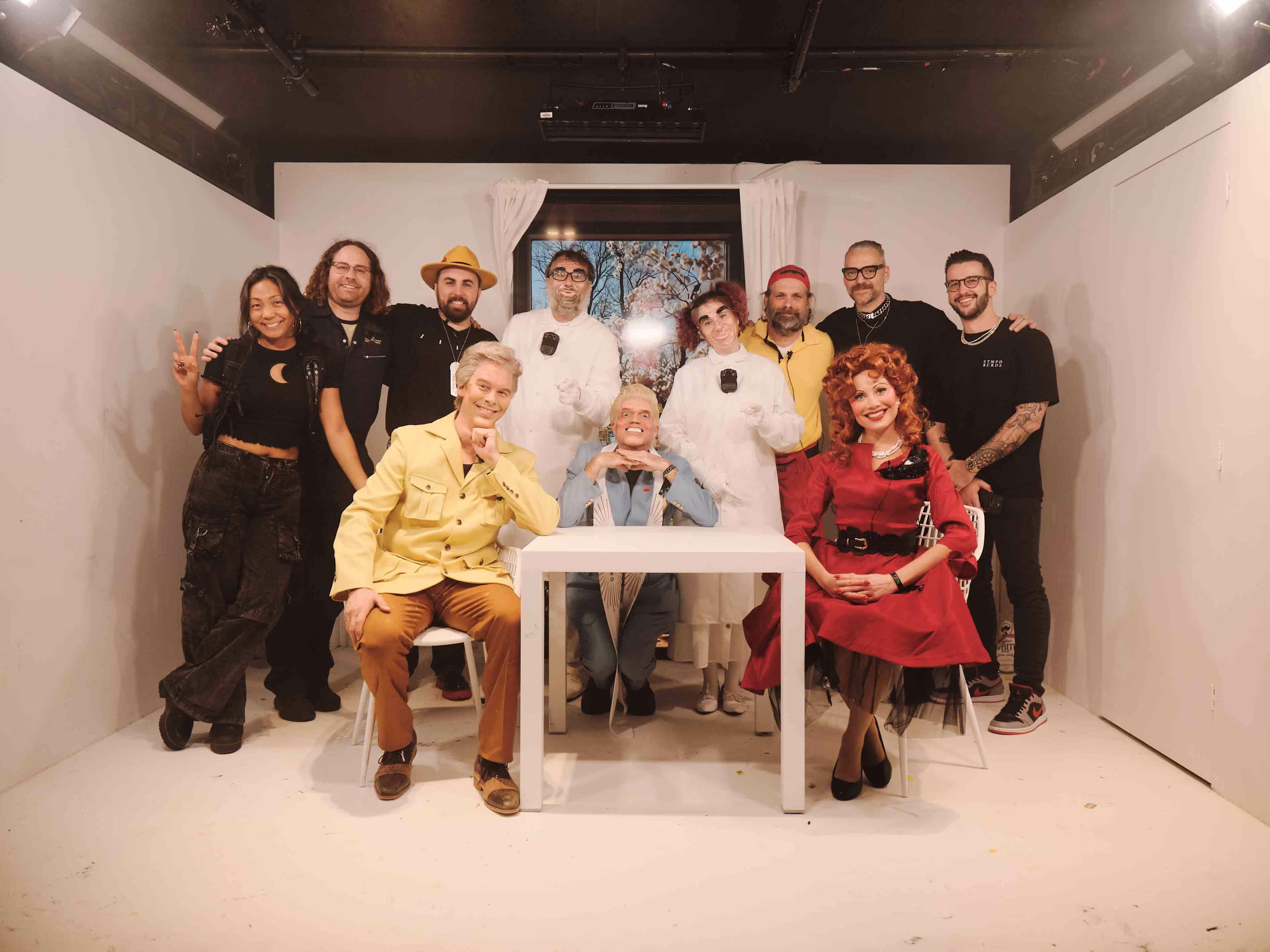A group of people standing and sitting around a table.