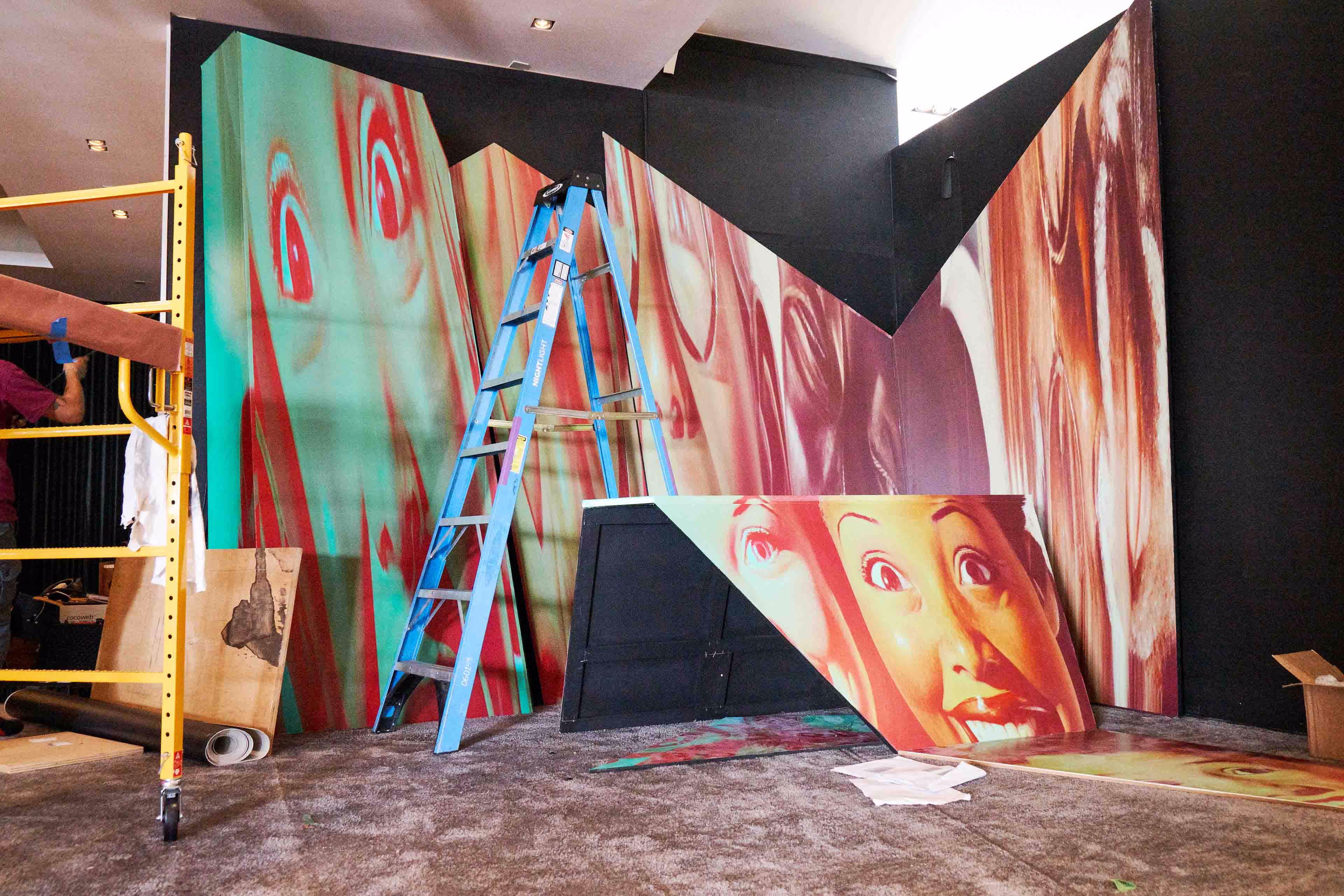 A man is painting a mural on a wall.