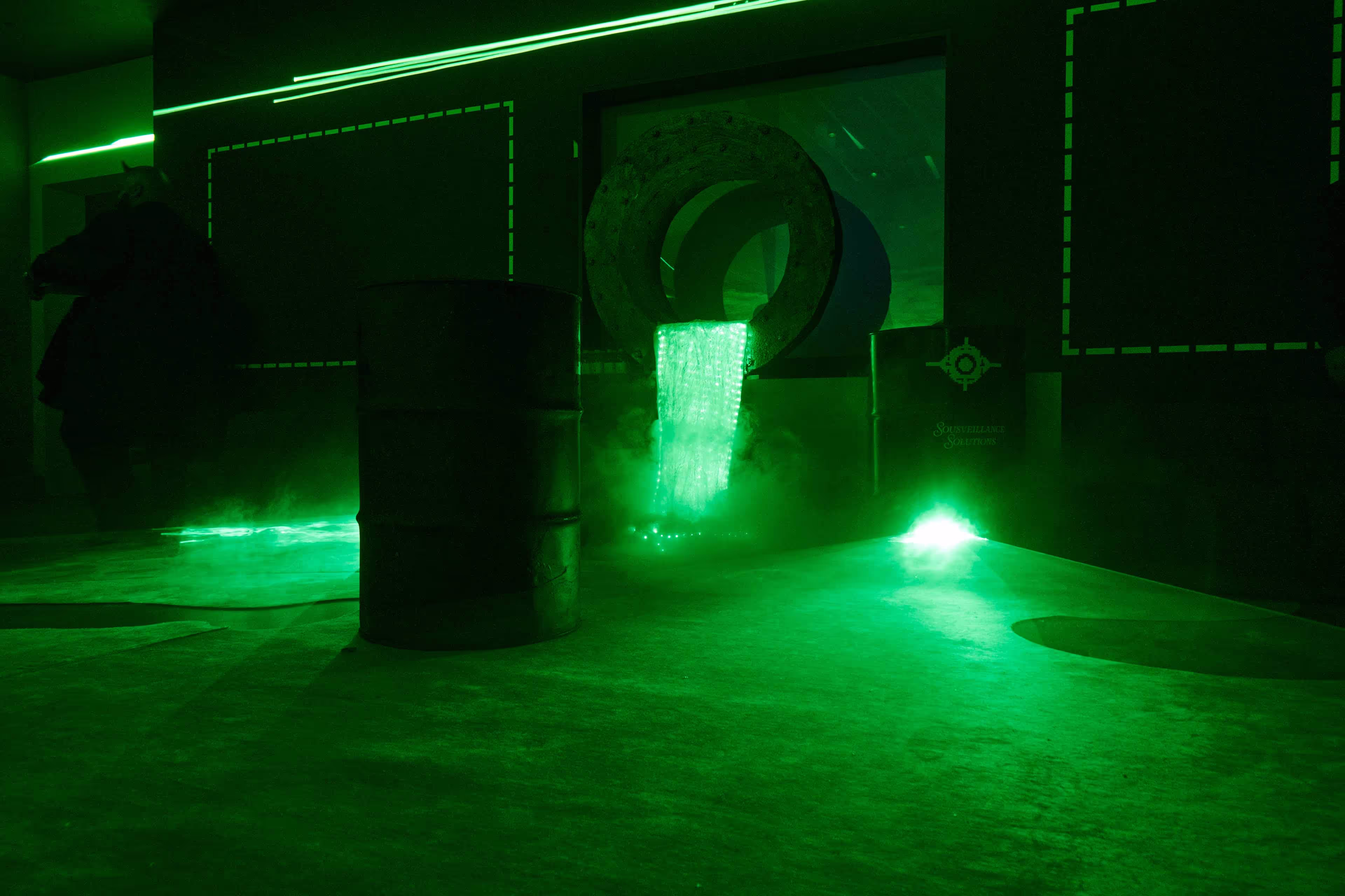 A green light shines on the floor of a building.