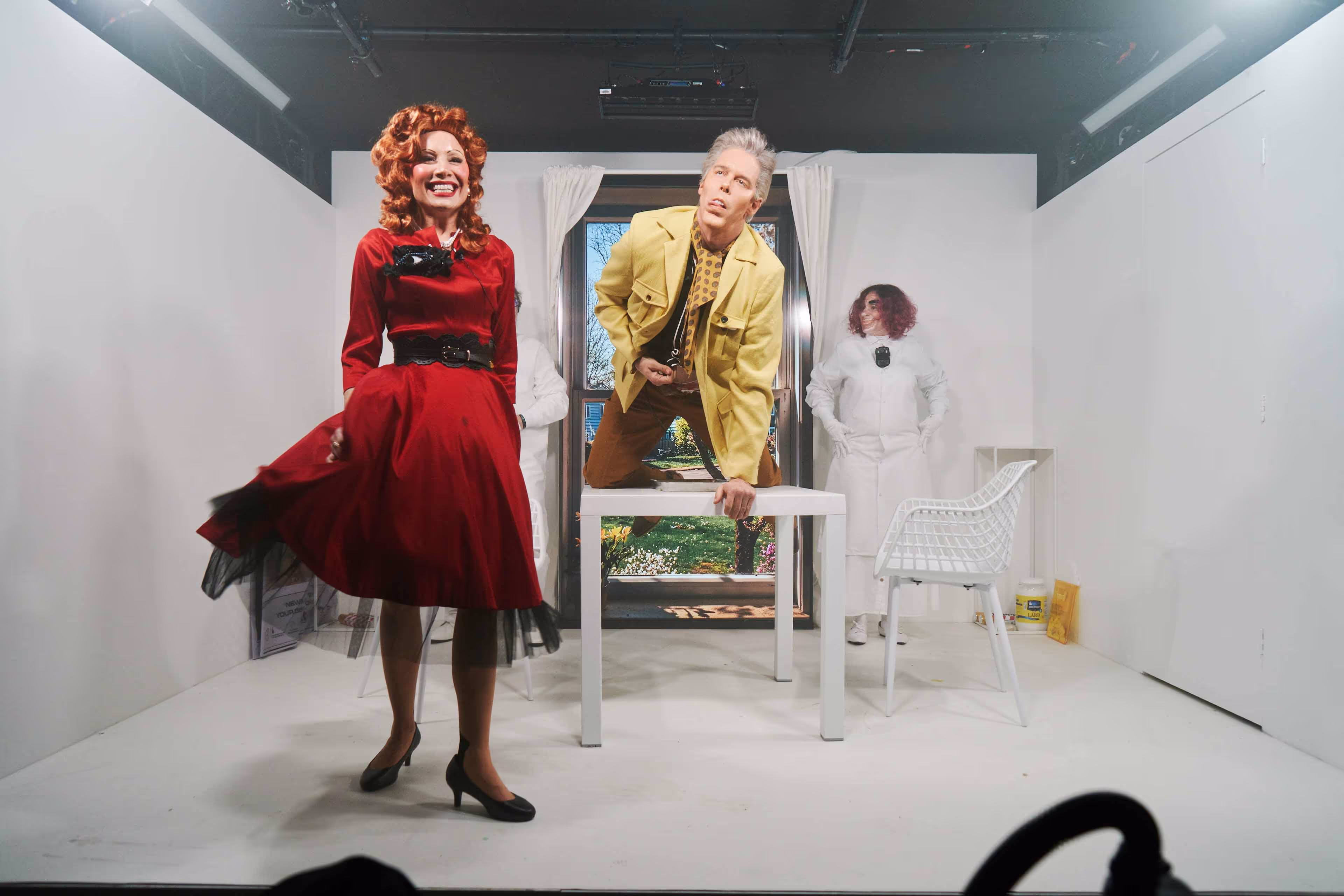 A woman in a red dress standing next to a man in a yellow jacket.