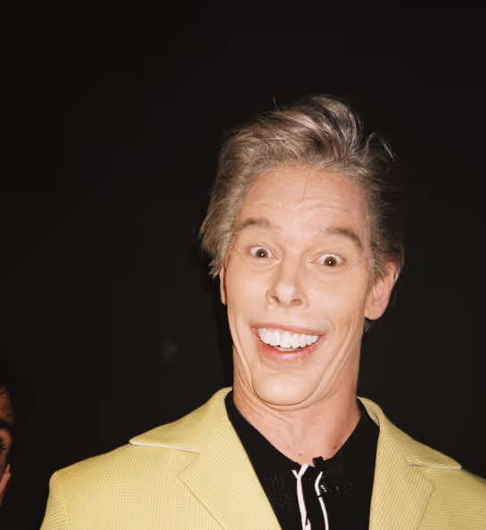 A man in a yellow suit and black shirt.