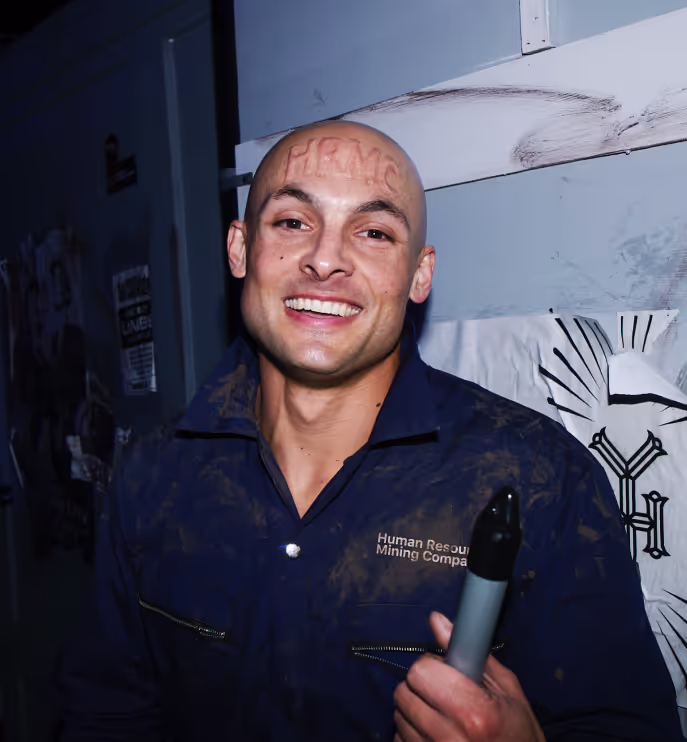 A man with a bald head holding a broom