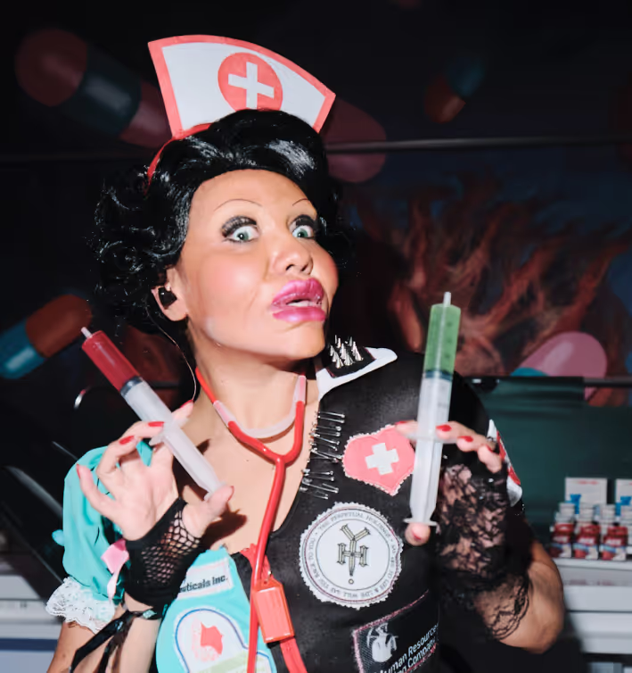 A woman dressed as a nurse holding a syringe