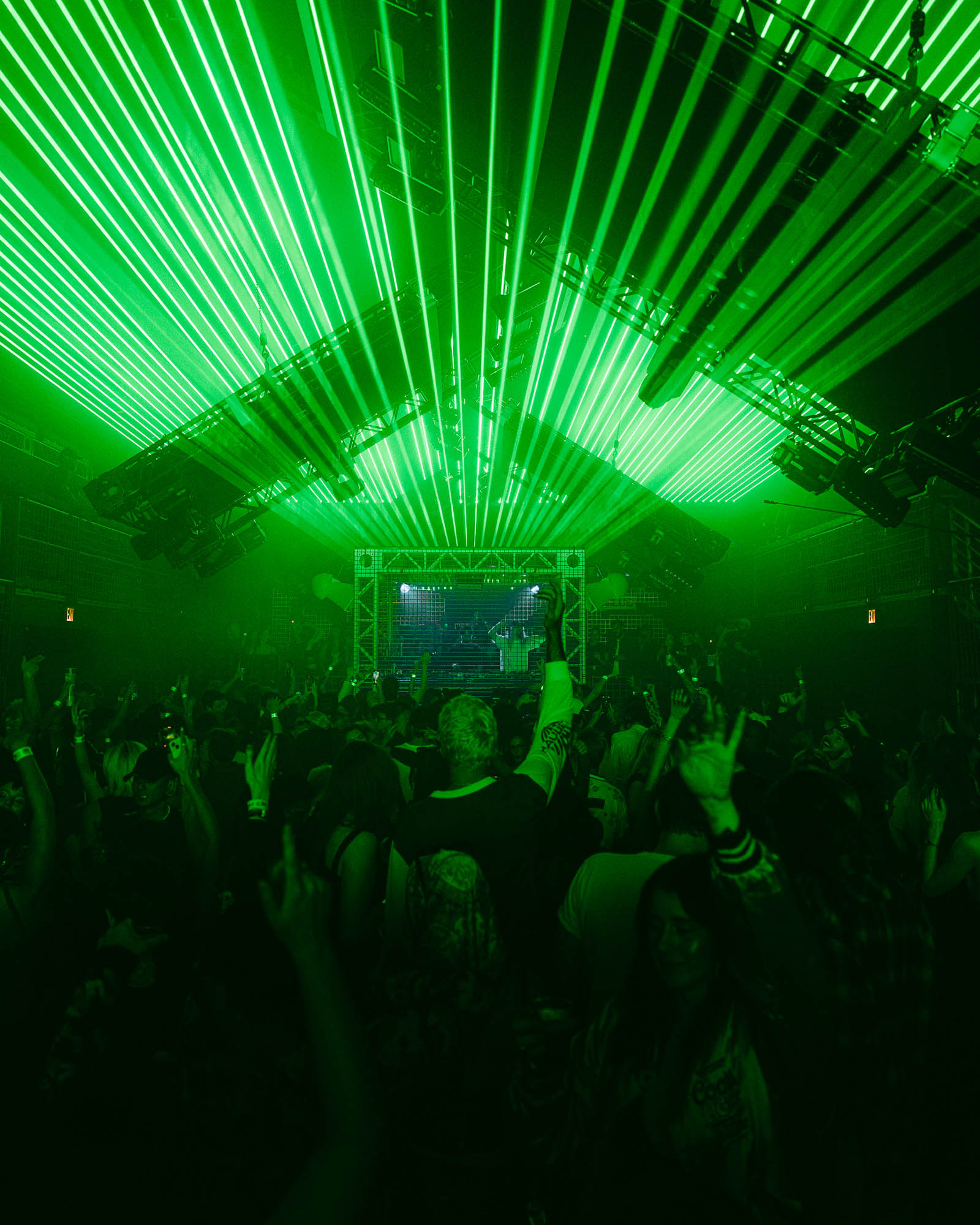 A crowd of people at a concert with green lights.
