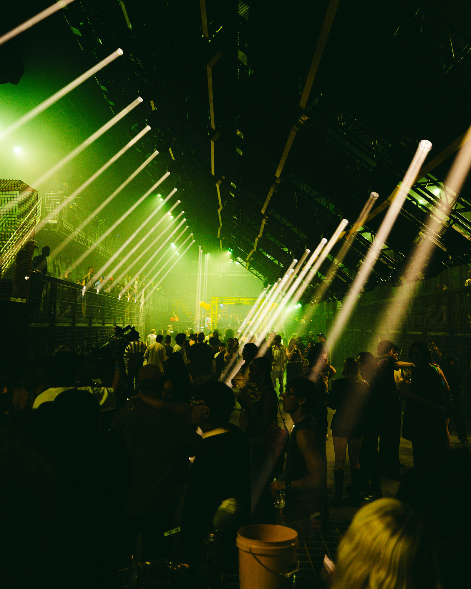 A crowd of people standing around a stage with lowered truss
