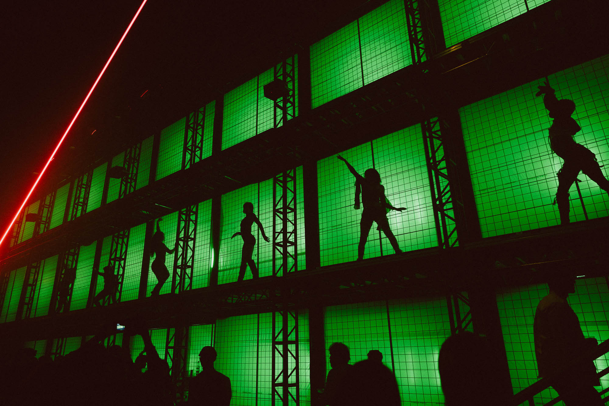 cage dancers with fluorescent green backlighting 