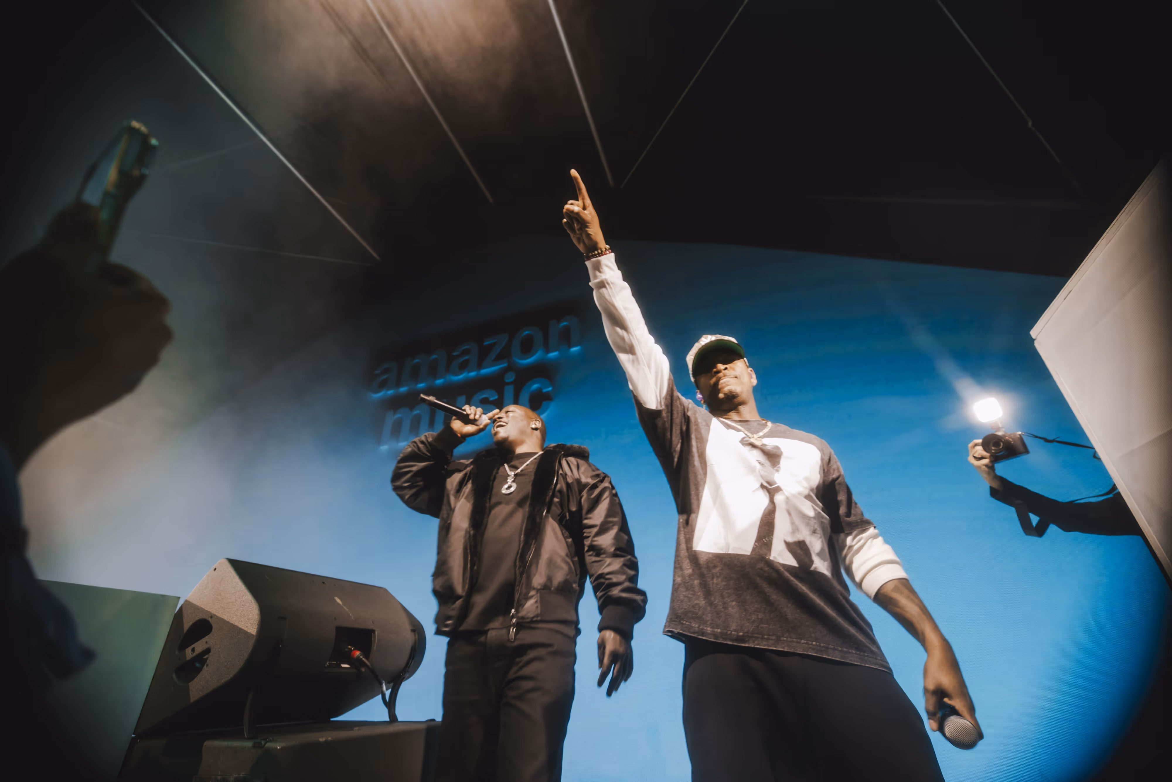 A couple of men standing on top of a stage.