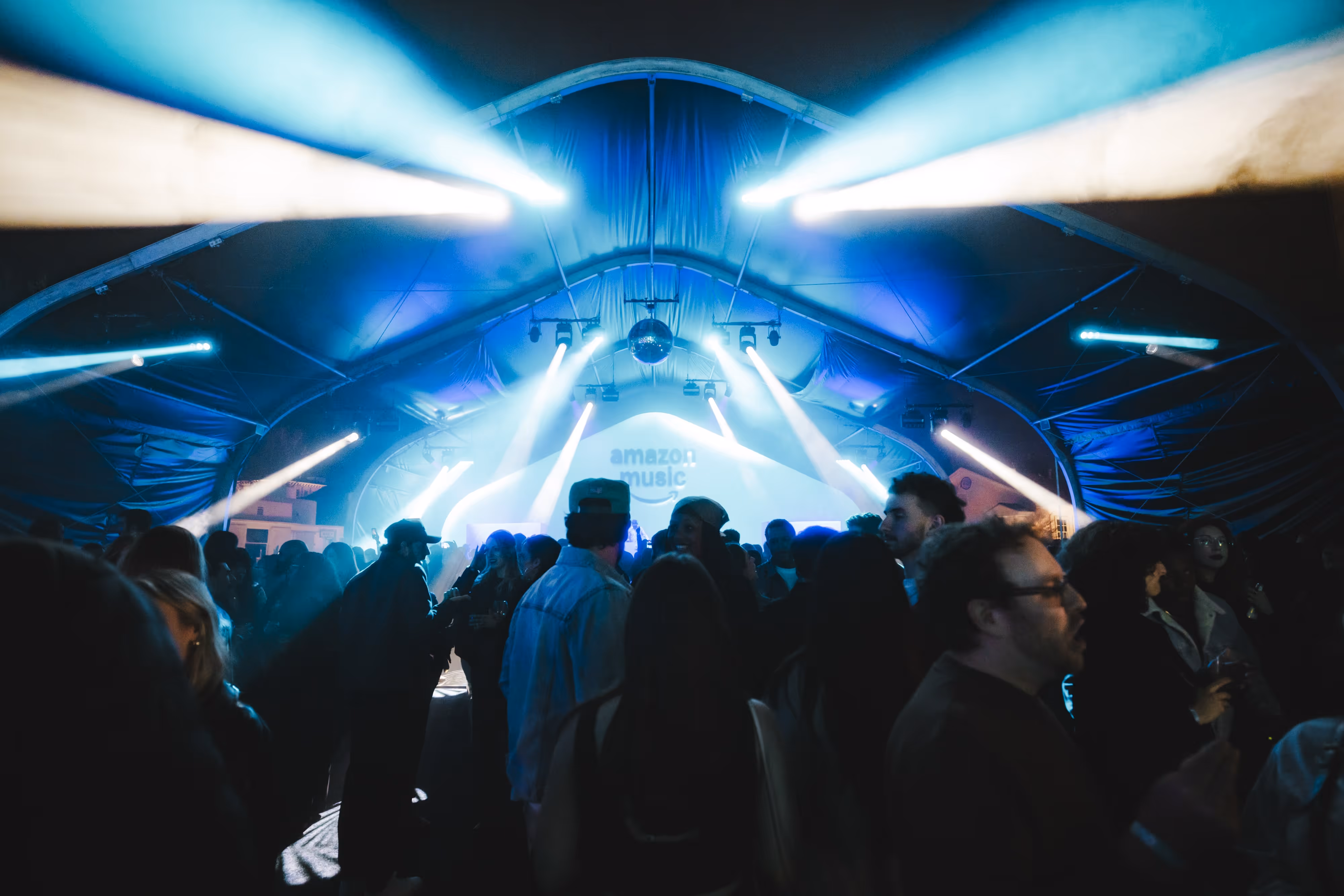 A crowd of people standing around a stage.