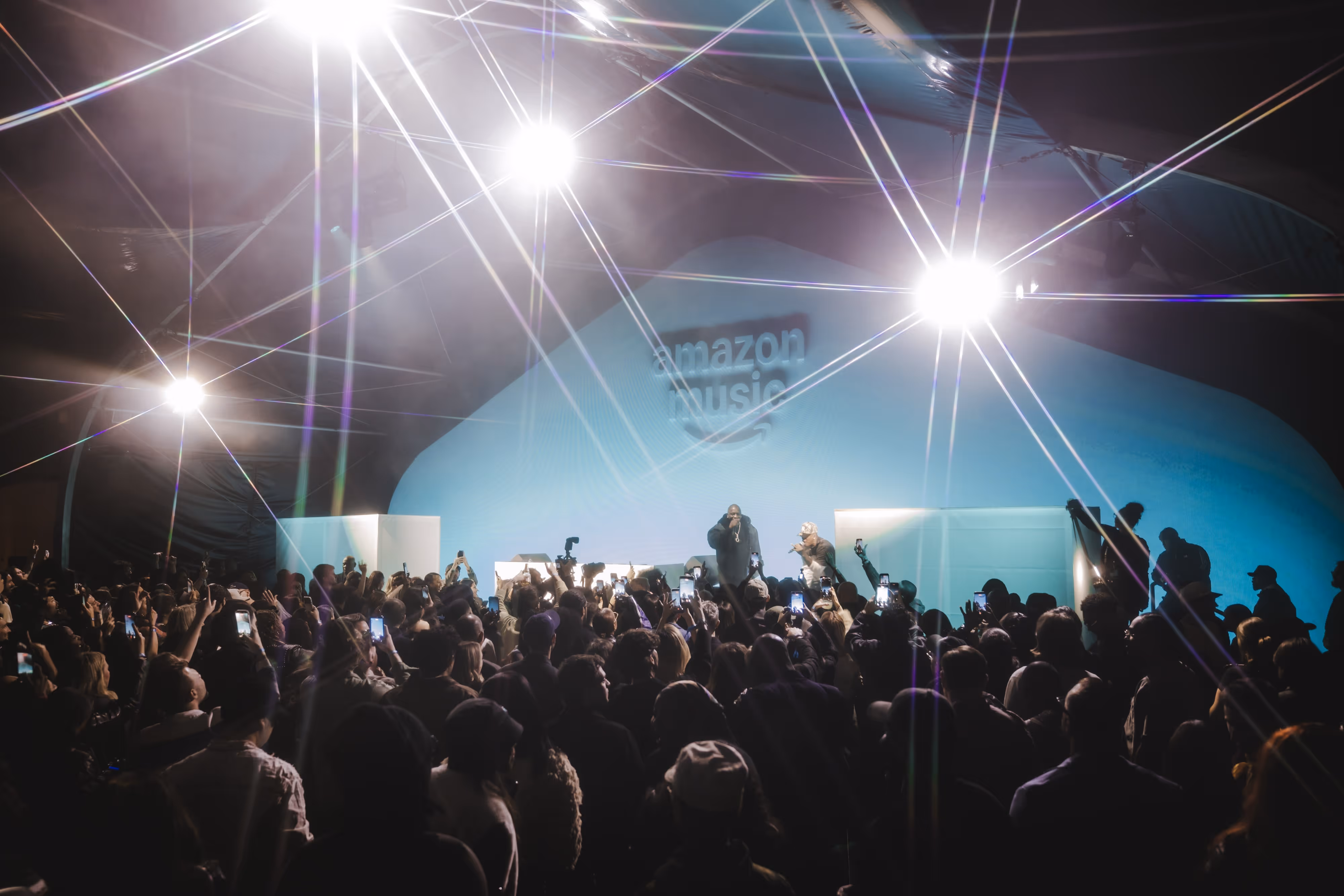 A crowd of people standing around a stage.