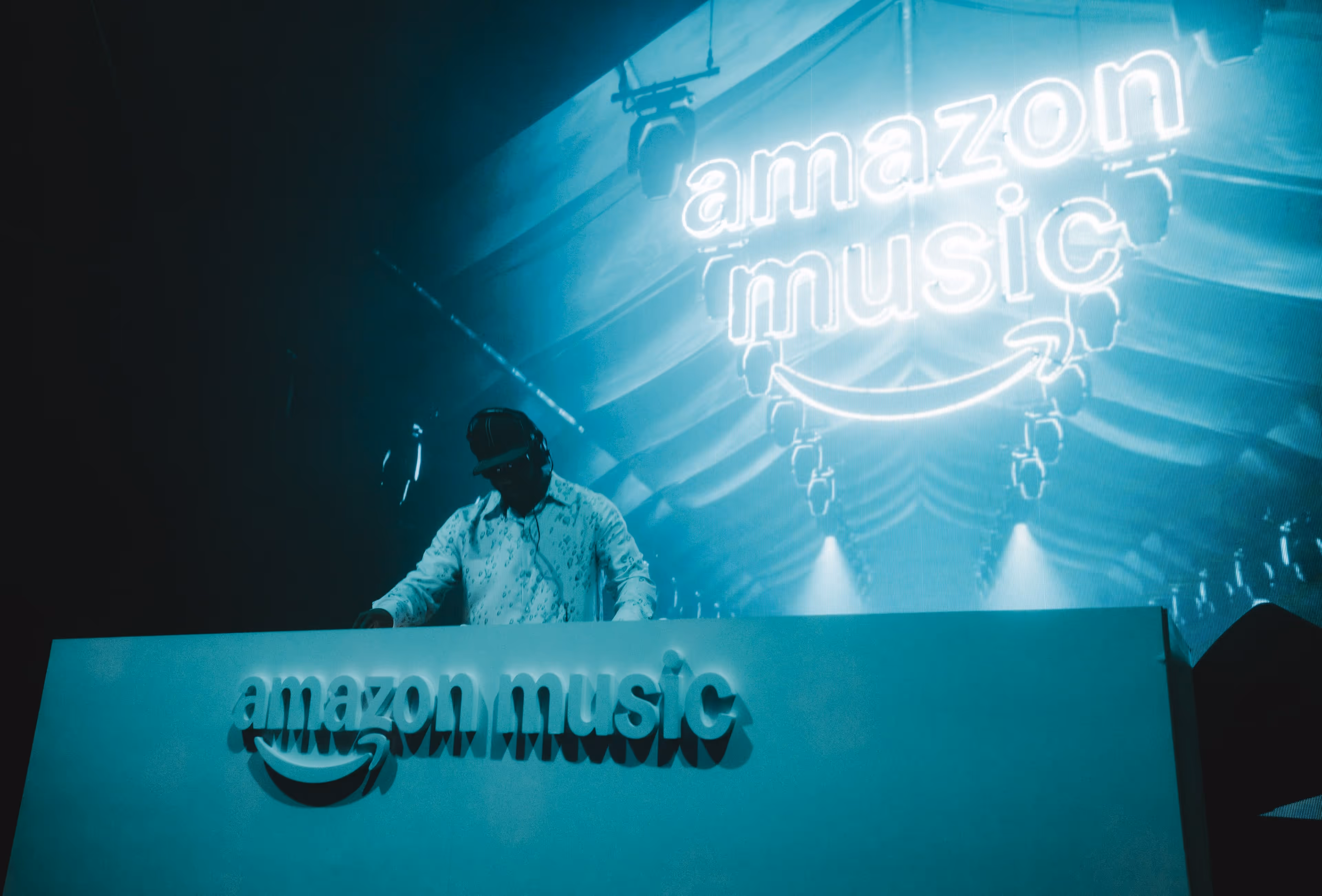 A man standing behind a sign that reads amazon music.