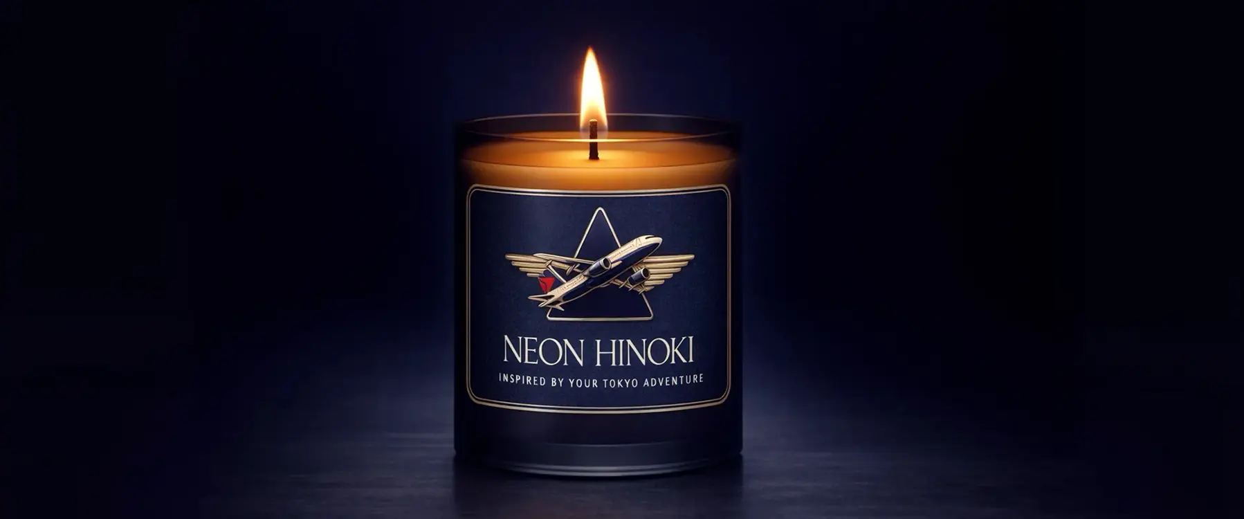 Image of a moody, dark studio with a lit Delta candle in the middle and a badge in the center of the candle label with the name “NEON HINOKI” on the front.