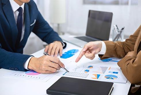 A picture of two people negotiating and pointing to a financial document signifying the Finance category of Independent Professionals on Equilink