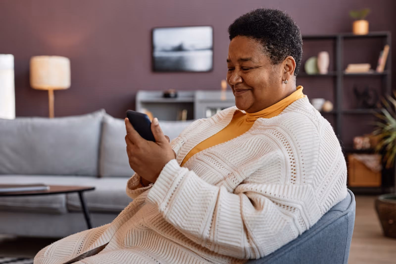 African American senior woman is looking up her blood sugar history on her phone.