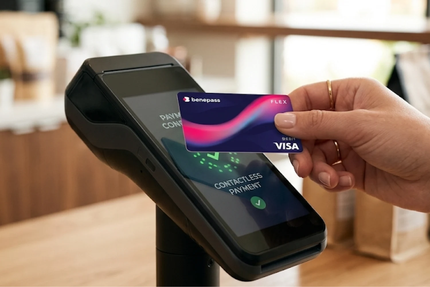 Close-up of a Benepass card being used for a contactless payment on a modern card terminal at a retail checkout.