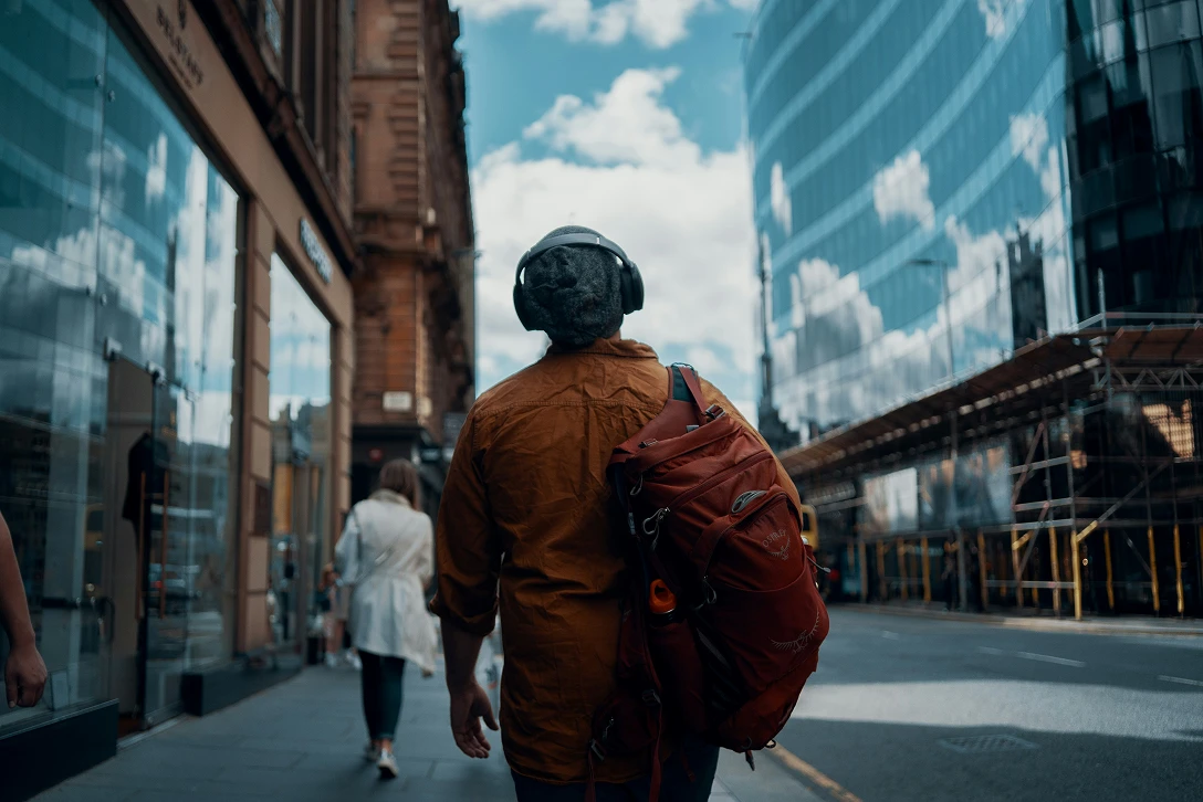 A person walking along the street carrying a backpack