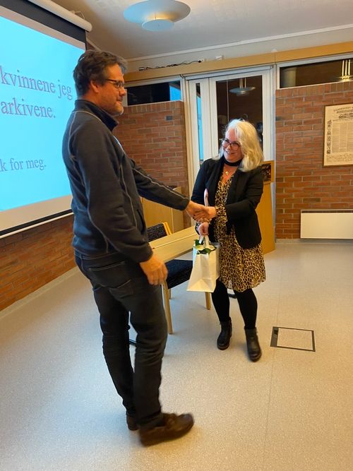 Bård Raustøl ved Arkivsenter sør overrekker blomster og gode ord til foredragsholder Line Francisca Hansen.
