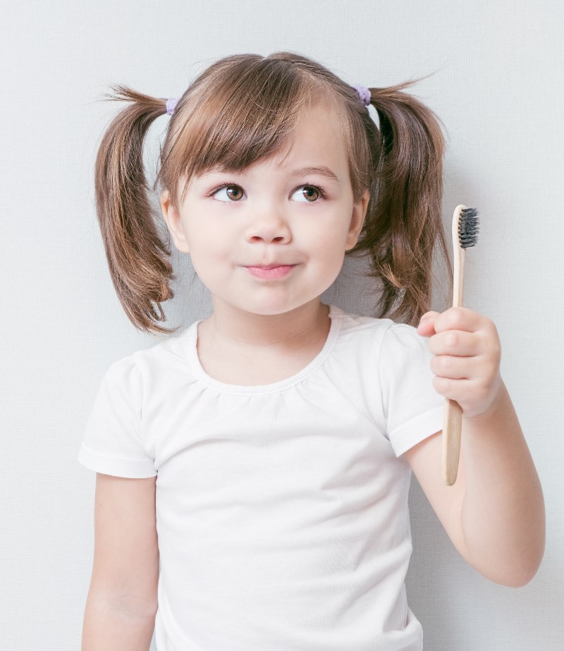 girl holding toothbrush