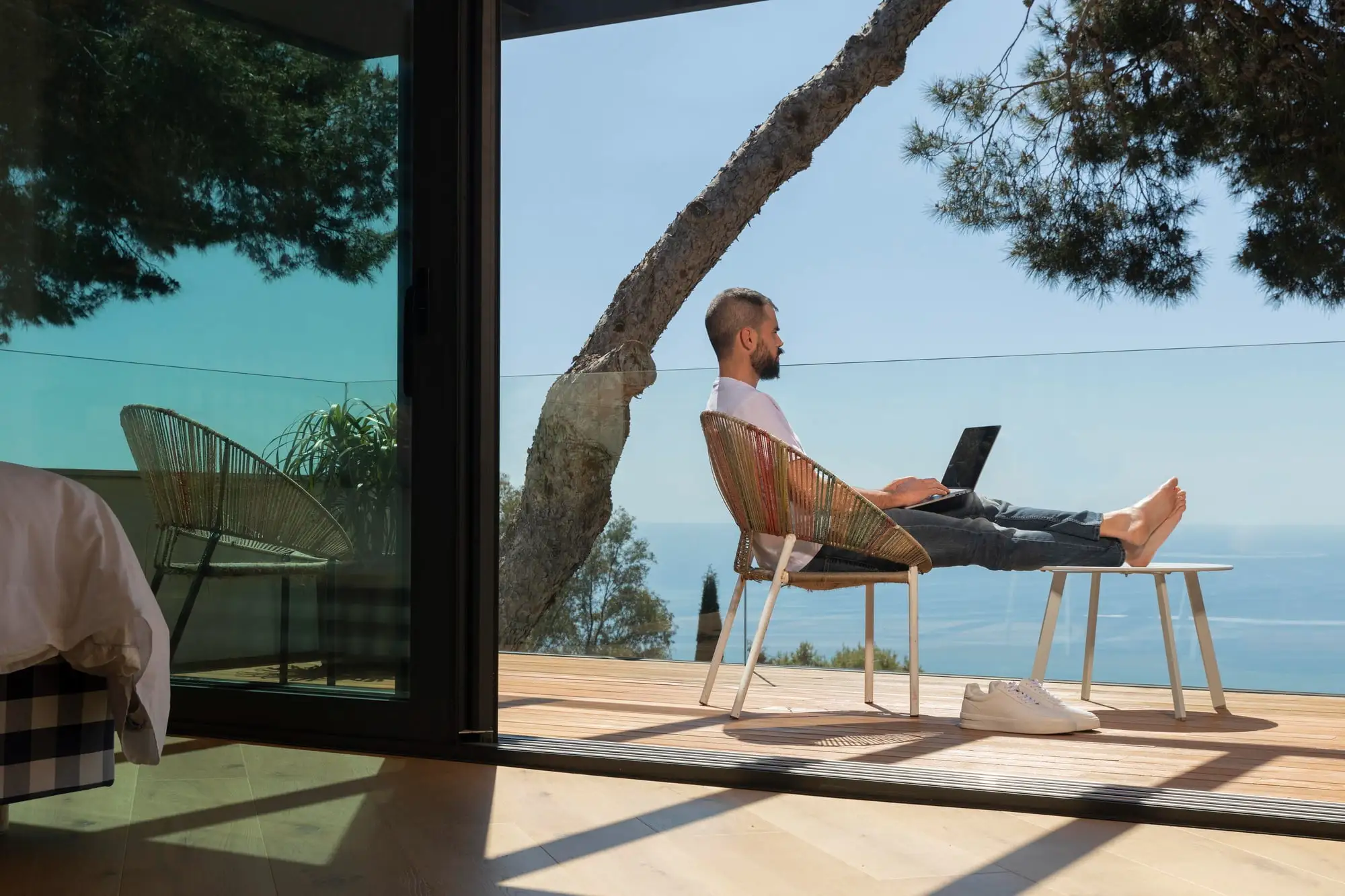 Man working remotely with sea view from his apartment balcony