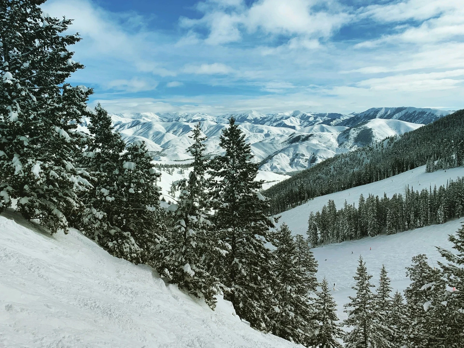 A mountain slope covered with fresh snow rises under a pale sky at Sun Valley Idaho.