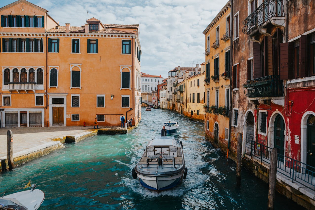  A view of a canal, a boat and colorful houses in the Canal Historic District in Venice, Italy.