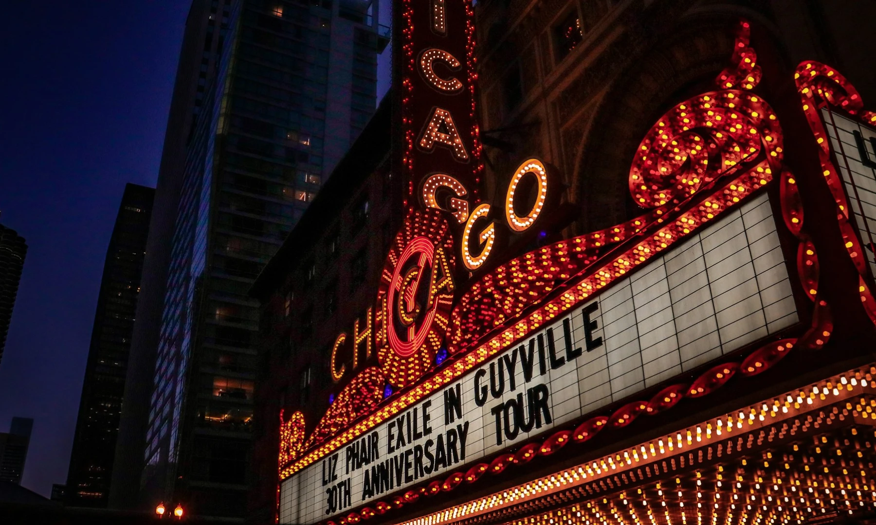 A glowing marquee at the famous theatre in Chicago, with illuminated signs spelling out the word Chicago, a cinema at night in Chicago, This venue is a must-see on any long layover in Chicago.