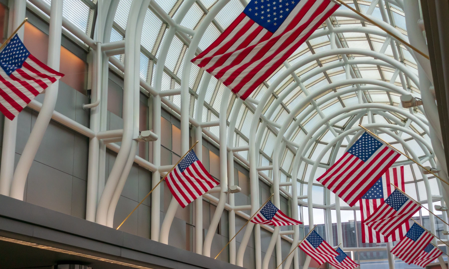 Unites States of America flags in red white and blue lined along a walkway at Chicago O'Hare International Airport in Chicago