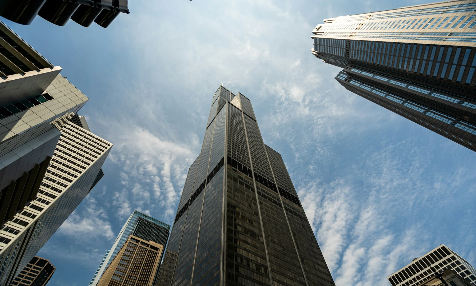 Famous landmarks standing tall in Chicago against a blue sky, this skyline includes the famous Willis Tower