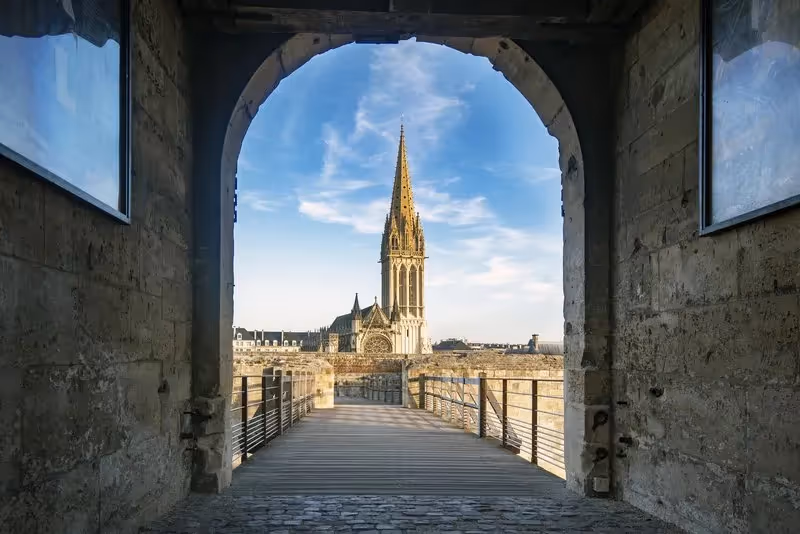 Vue sur la cathédrale de Caen depuis une arcade médiévale.