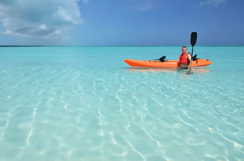 Voyageur en kayak orange sur une mer turquoise peu profonde aux îles Perhentian.