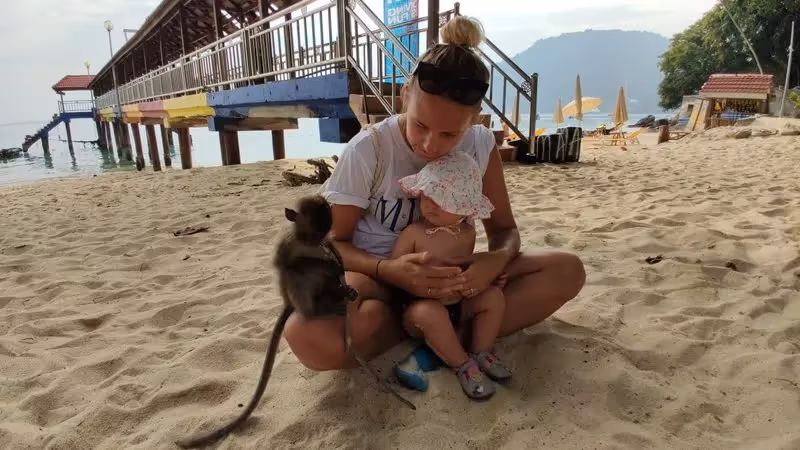 Maud et Anna rencontrent un petit singe sur la plage des îles Perhentian.