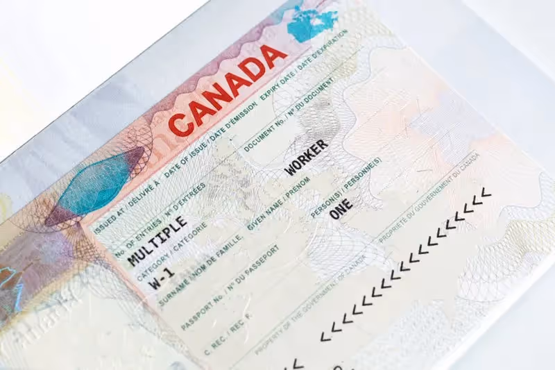 Visa de travail canadien collé dans un passeport, indiquant une autorisation multiple.