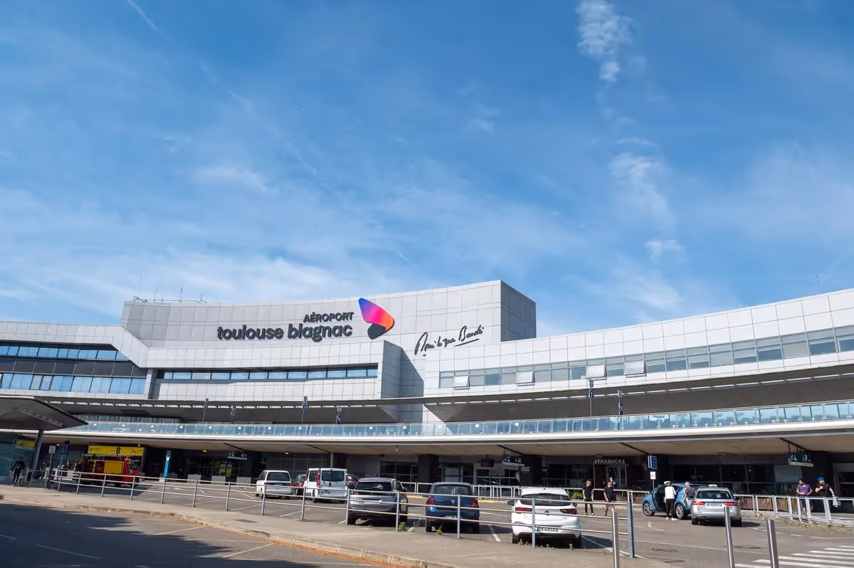 Façade principale de l’aéroport Toulouse Blagnac, zone départ sous ciel bleu