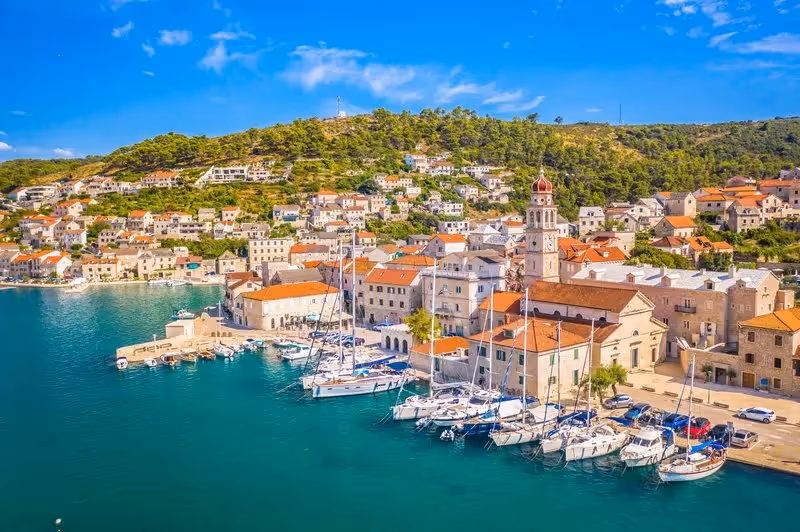 Vue sur le port de Supetar, village principal de l’île de Brač, avec ses bateaux et maisons en pierre blanche.